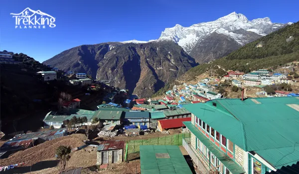 Travelers exploring the vibrant local market in Namche Bazaar surrounded by Himalayan peaks.