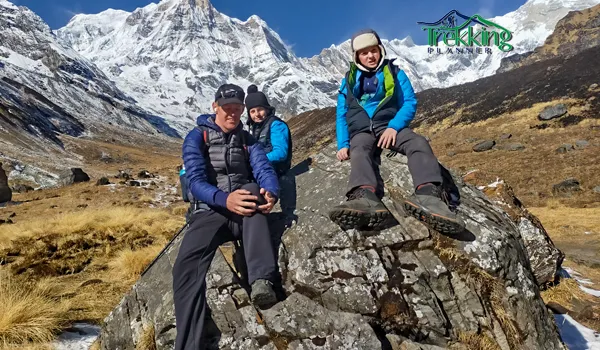 Children hiking with parents enjoying panoramic mountain views during a trekking adventure