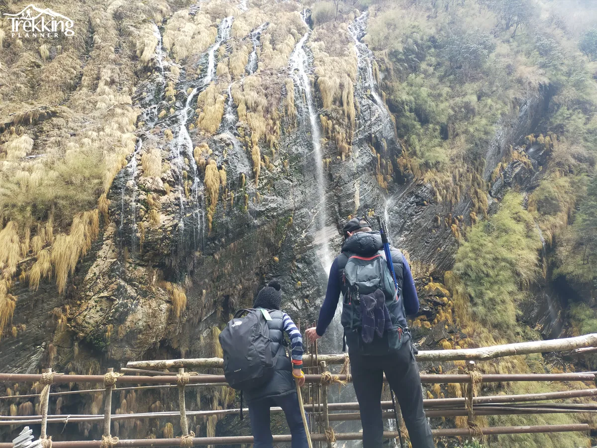 Hikers walking along rocky ridge trail on Annapurna Skyline Trek with mountains in background