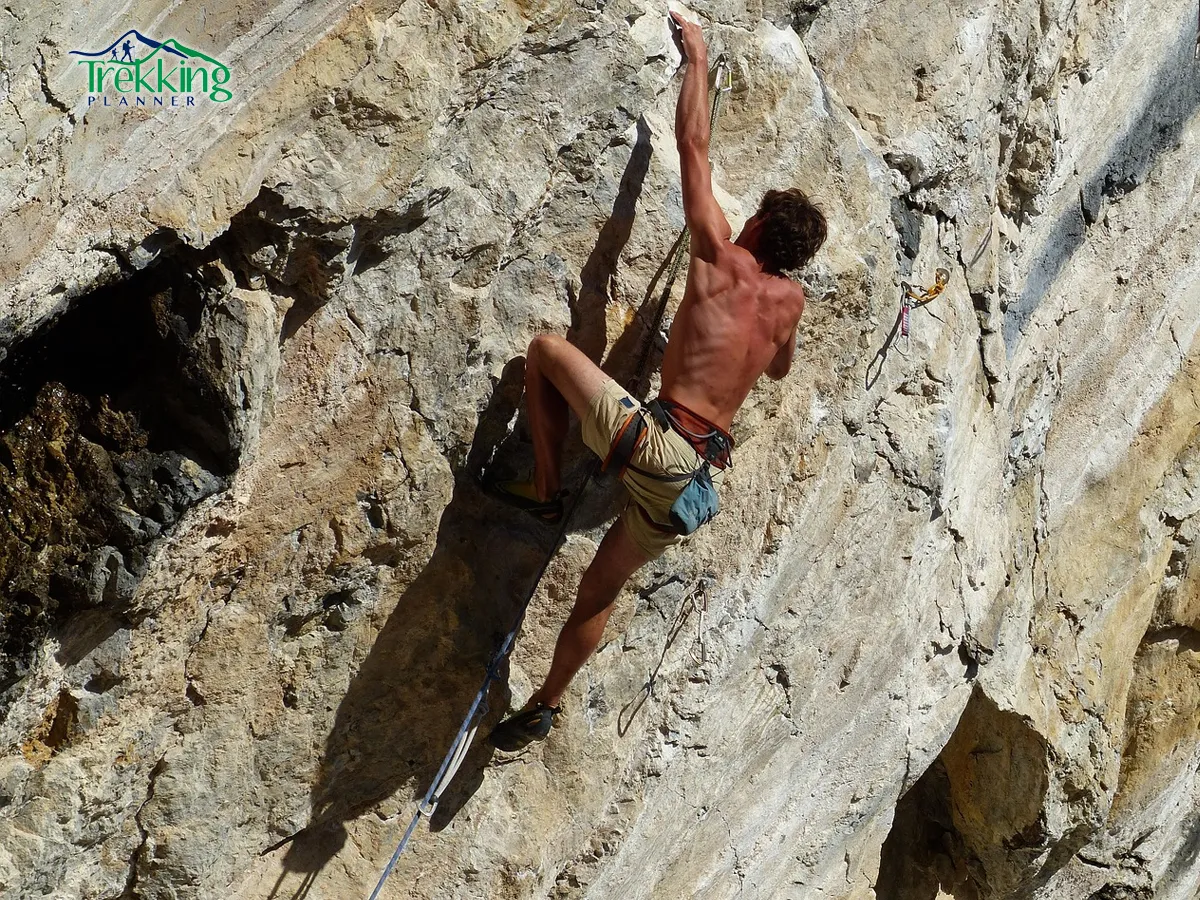Beginner climber learning safety techniques on a rock climbing wall