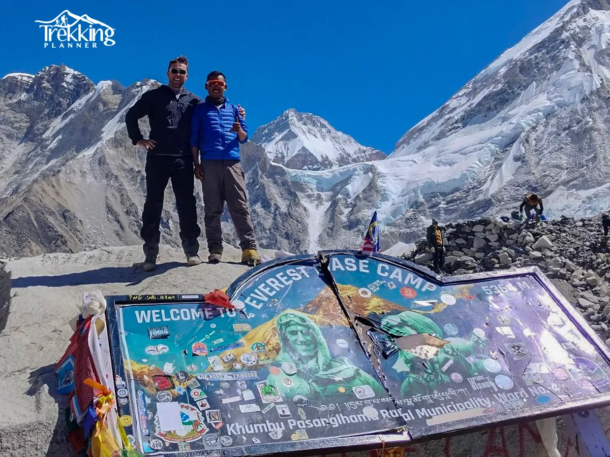 Trekkers walking on the Everest Base Camp trail through the Himalayas with snow-capped peaks in the background