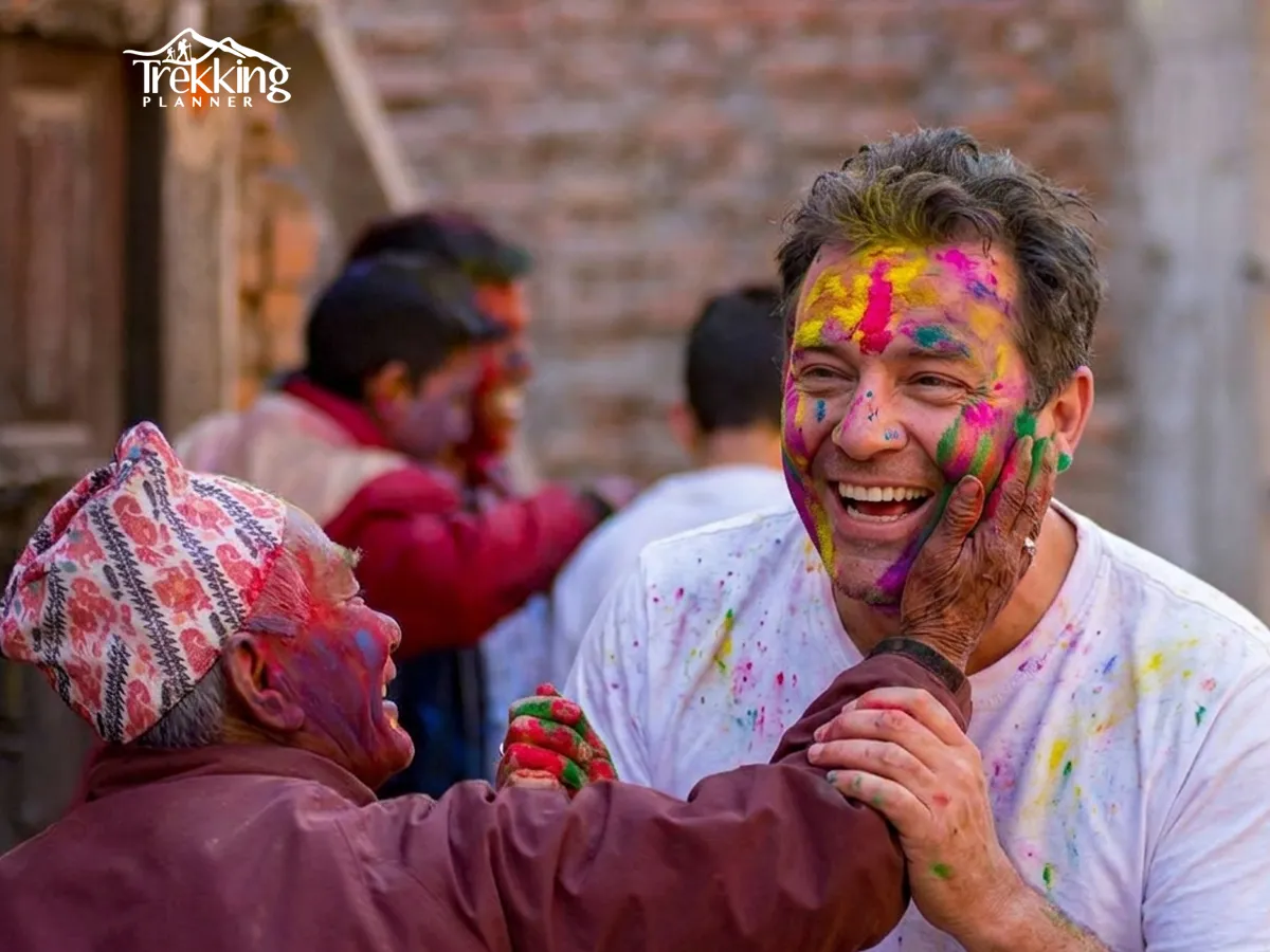 Tourists and locals enjoying Holi festival in Nepal throwing colored powder and water during celebration