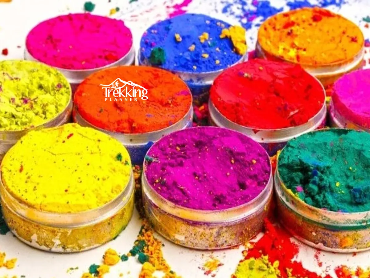 Group of friends celebrating Holi in Nepal smiling and throwing vibrant colored powder in the air
