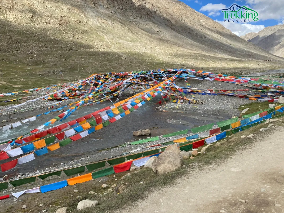 Colorful prayer flags and pilgrims on the Kailash and Manasarovar Pilgrimage Tour route in Tibet
