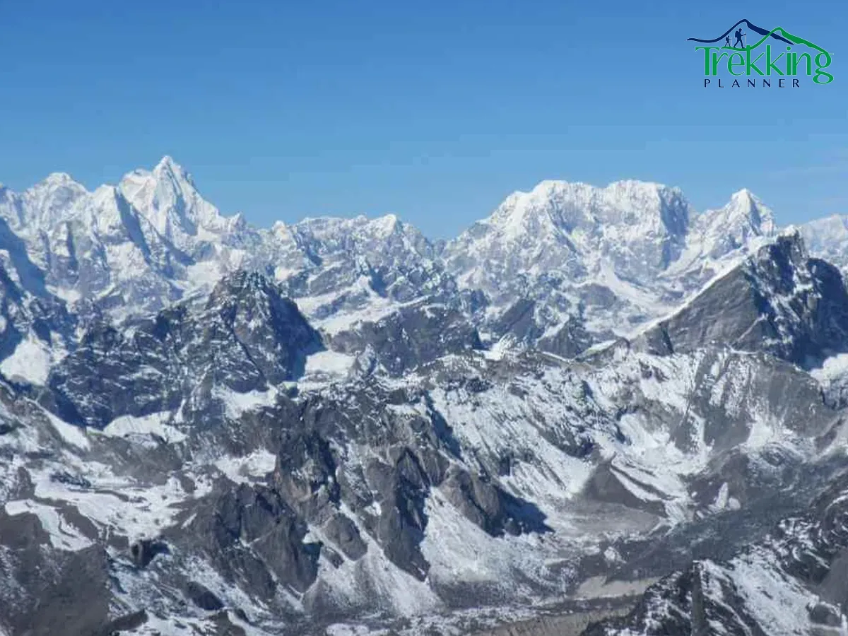 Climber ascending the snowy ridge of Pokalde Peak with panoramic Himalayan views in Nepal