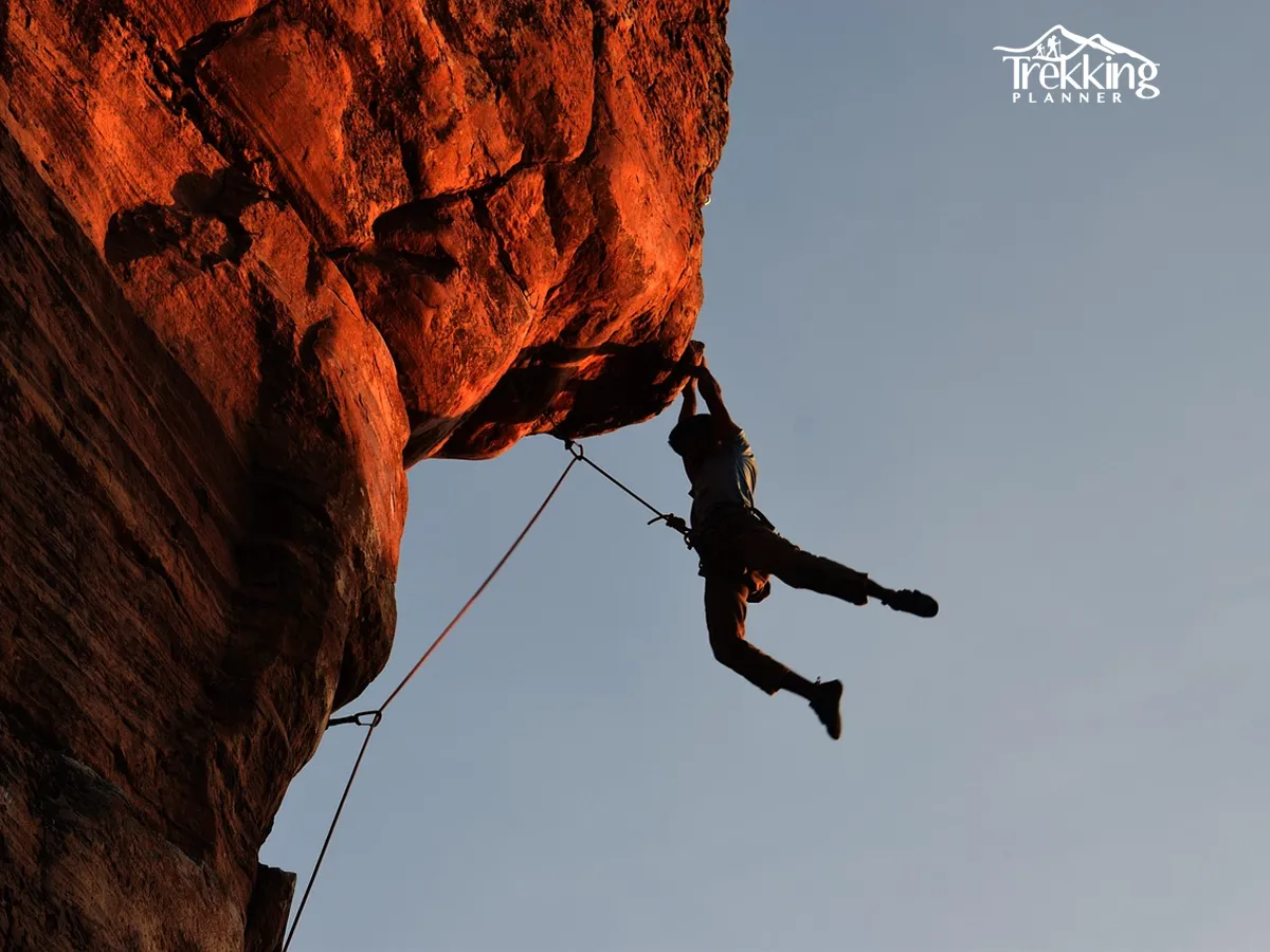 Adventurer scaling a vertical rock face during a rock climbing adventure in Nepal