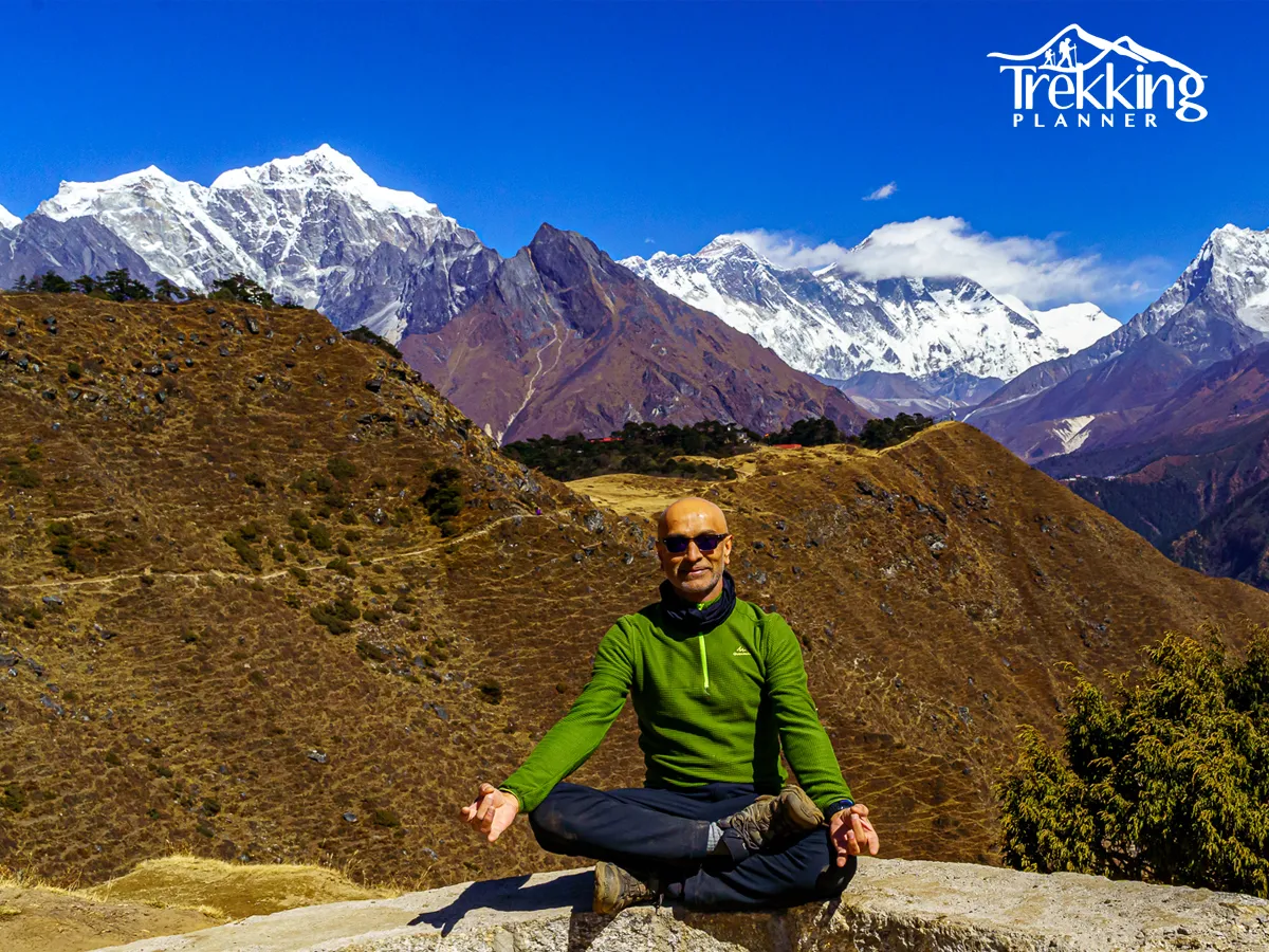 Solo practitioner doing silent yoga meditation near a peaceful lake in Nepal mountains