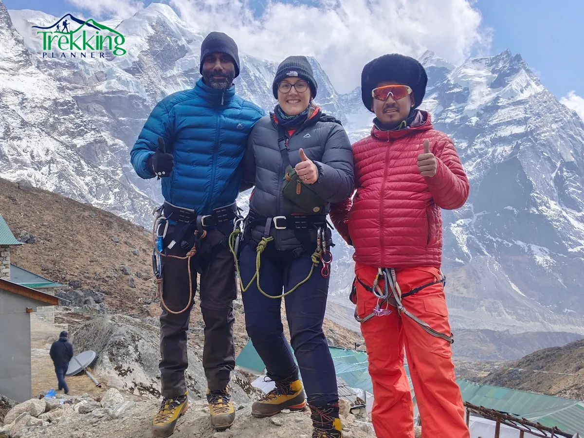 Mountaineers celebrating at the summit of Mera Peak with Everest visible in the background
