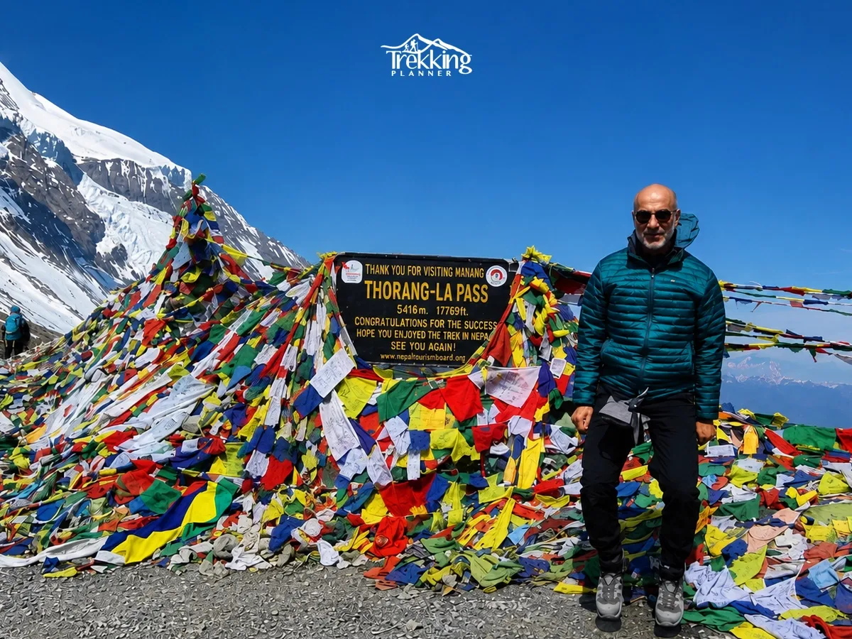 Trekker at Thorong La Pass (5,416m) during the Annapurna Circuit Trek with Tilicho Lake and Annapurna Base Camp.