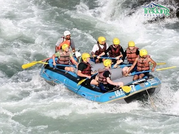 Group of tourists enjoying Sunkoshi River rafting expedition through fast flowing rapids in Nepal