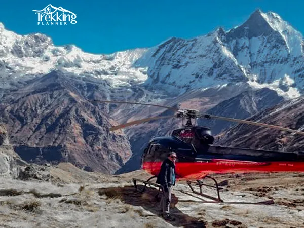 Helicopter parked at Annapurna Base Camp surrounded by snow-capped peaks during a helicopter tour