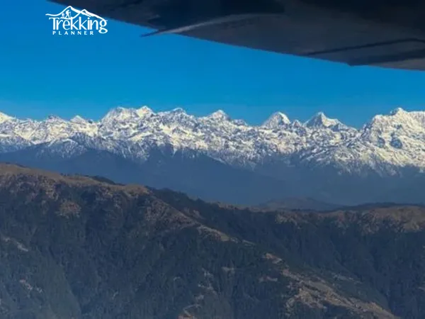 Aircraft flying above snow-capped Himalayan mountains during a mountain flight in Nepal.