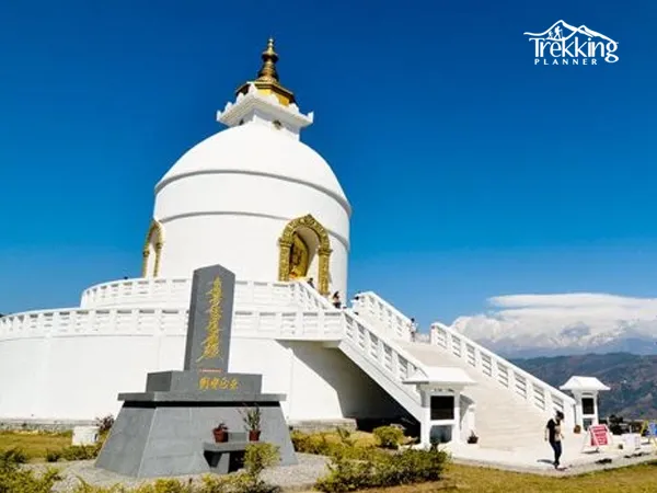 Visitors relaxing at Shanti Stupa after a day hike with Annapurna mountain views in the background