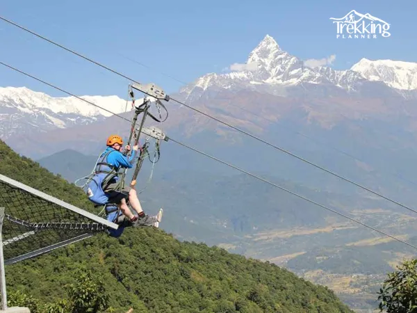Group of tourists zip lining in Nepal adventure tourism activity smiling and enjoying ride